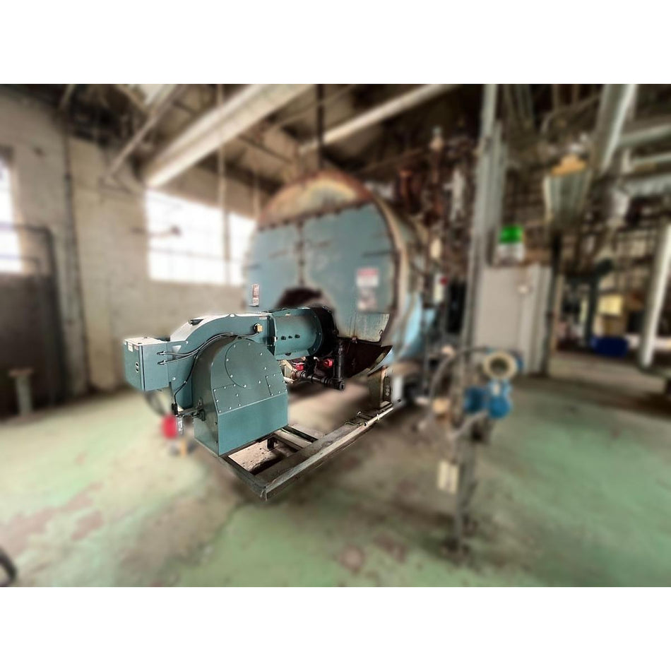 Cleaver Brooks 700HP industrial natural gas burner assembly skid-mounted and installed on Burnham 700HP three-pass steam boiler in industrial facility prior to removal