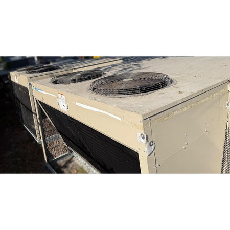 Daikin DPS012AHHE2DW-4 rooftop HVAC unit top view showing dual condenser fan motors with wire guards, beige powder-coated cabinet, and condenser coil section