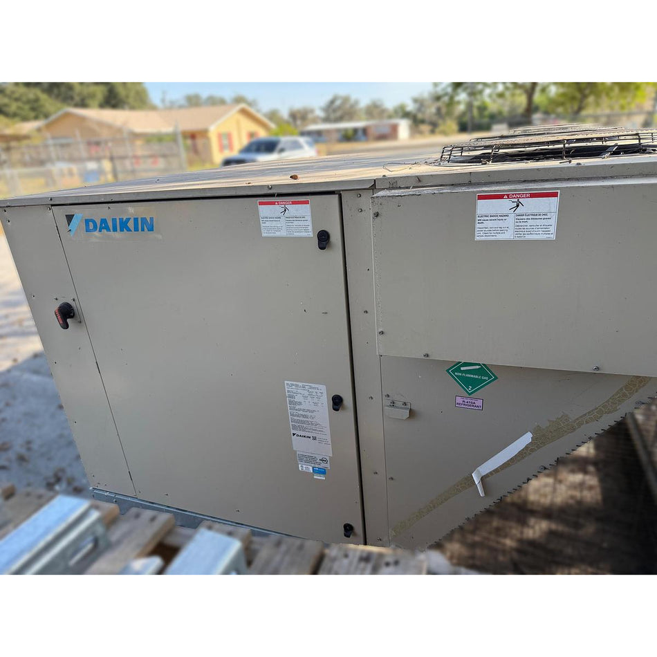 Daikin DPS012AHHE2DW-4 packaged rooftop HVAC unit showing beige powder-coated cabinet, R-410A refrigerant label, condenser fan grille, and safety warning labels, 2020