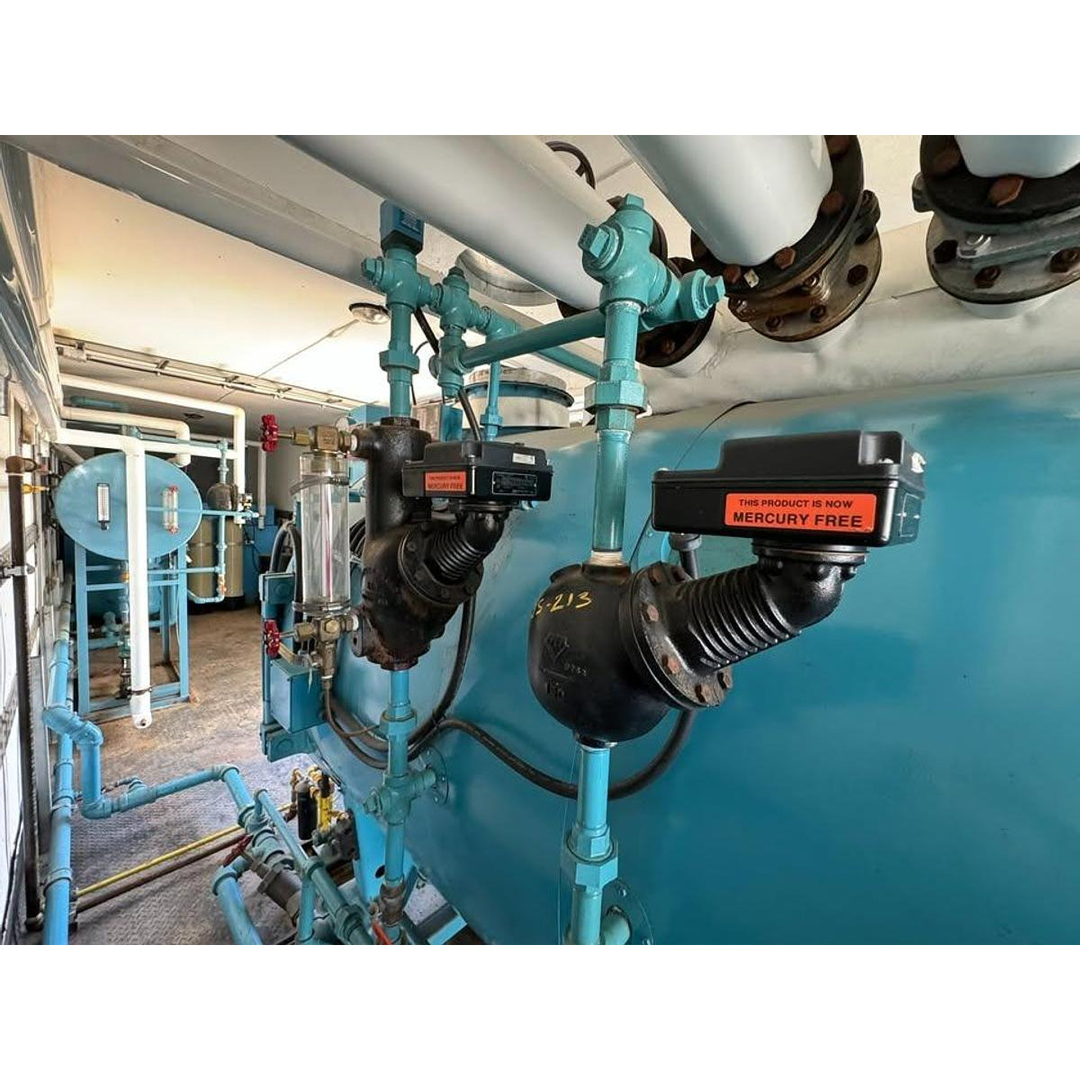 Industrial setting with blue pipes and machinery in a room.