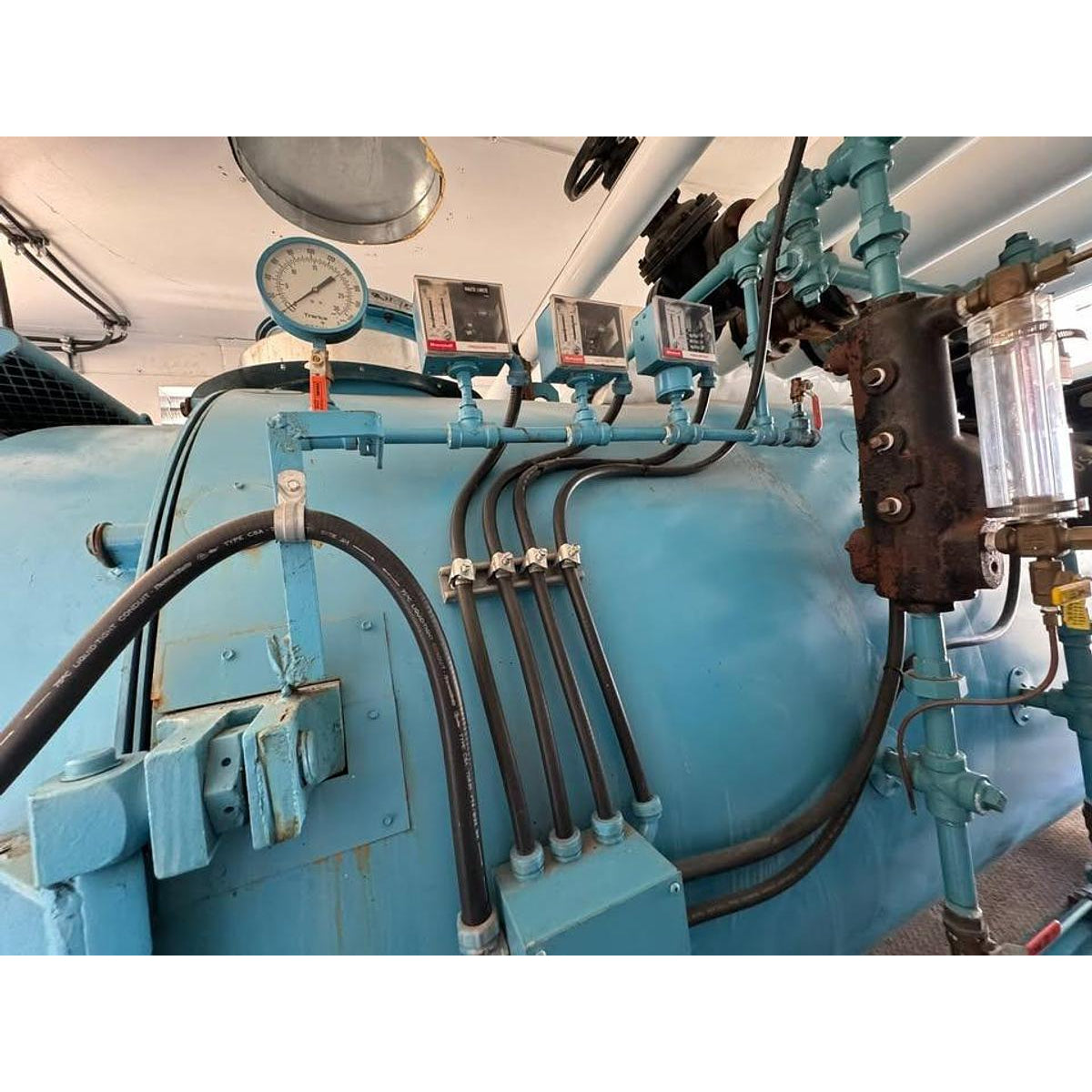 Blue mechanical system with pipes and gauges on a white background