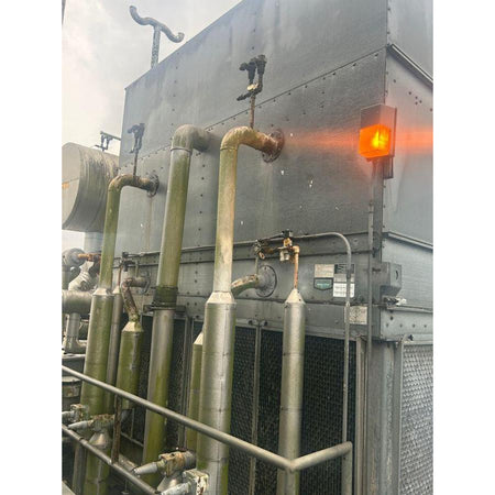 Industrial cooling tower with pipes and a red light indicator
