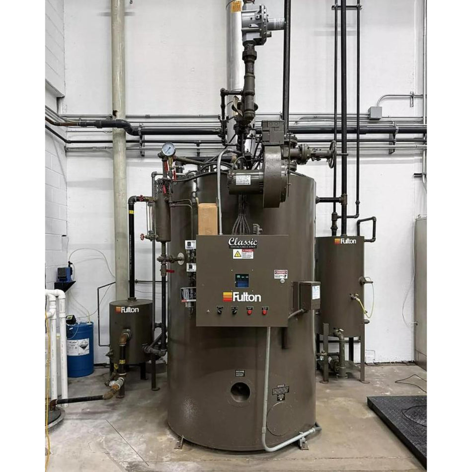 Fulton industrial boiler in a mechanical room with pipes and equipment.