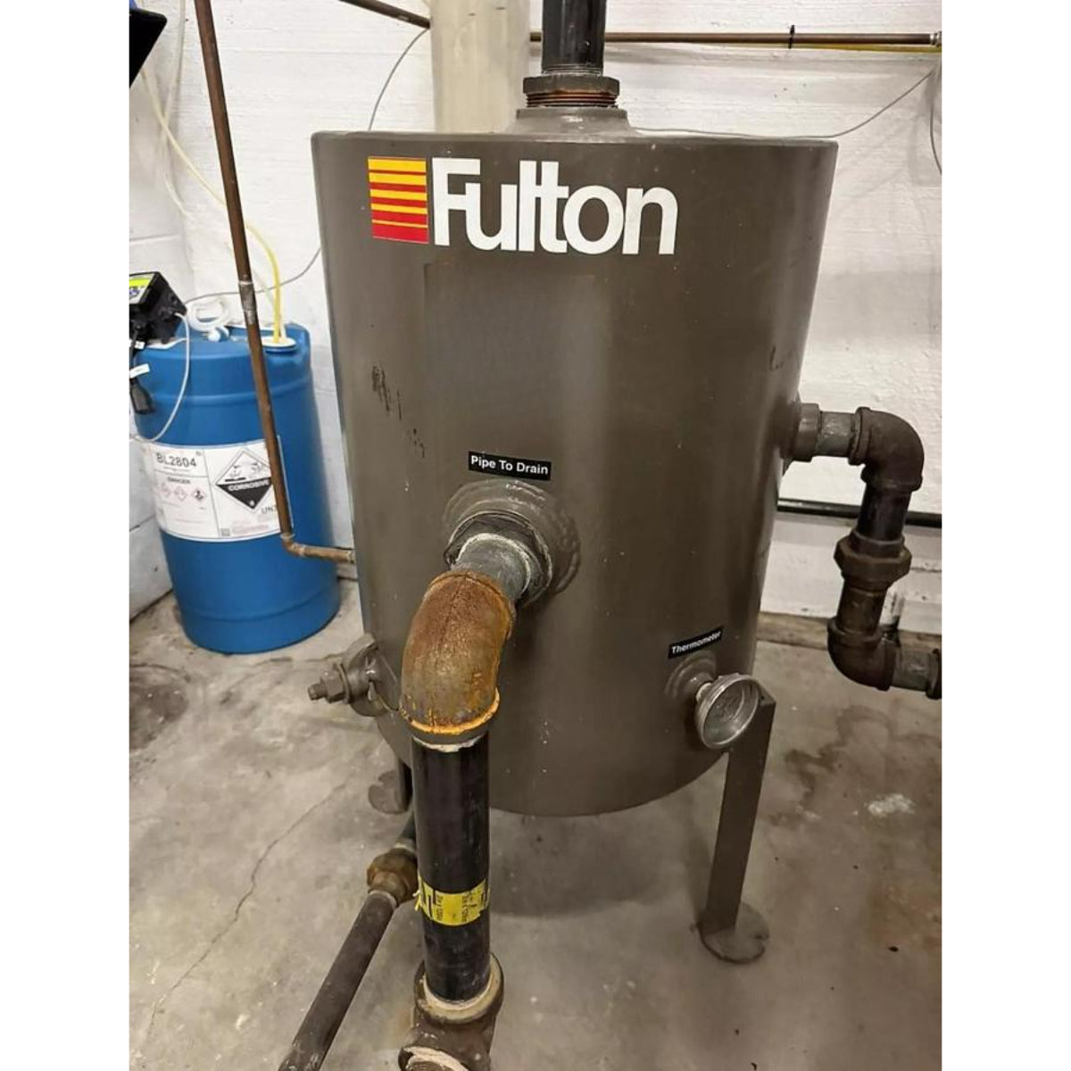 Fulton water heater with visible branding in a mechanical room setting.