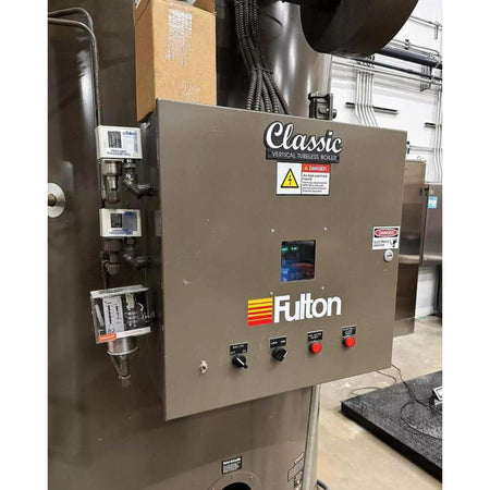 Control panel of a machine with 'Fulton' branding in an industrial setting