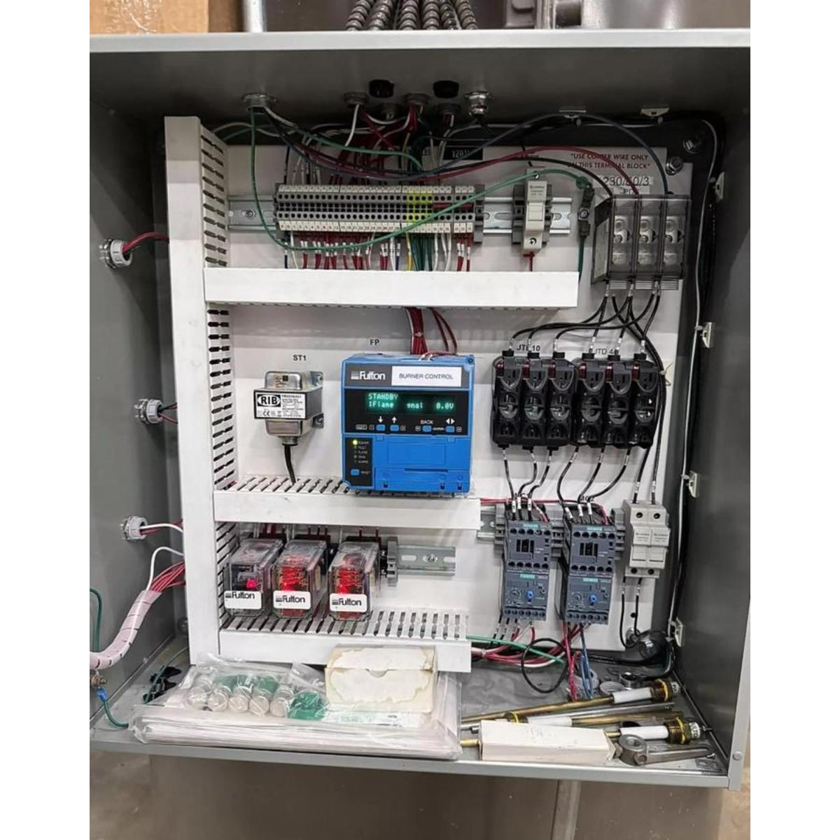 Electrical panel with various components and wiring inside a cabinet