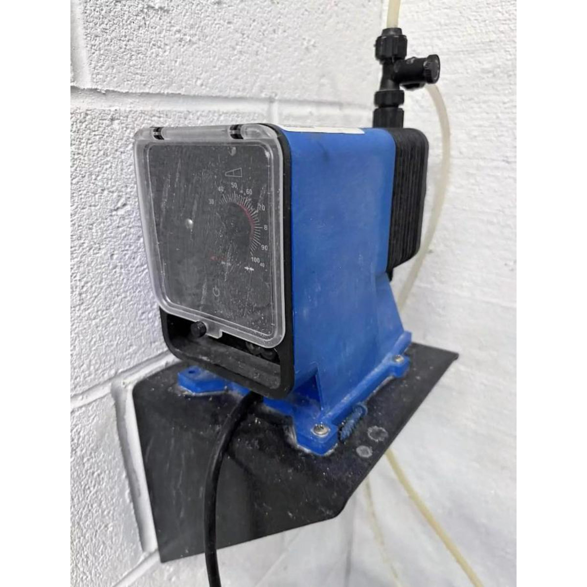 Blue electronic device with a control panel attached to a white wall.