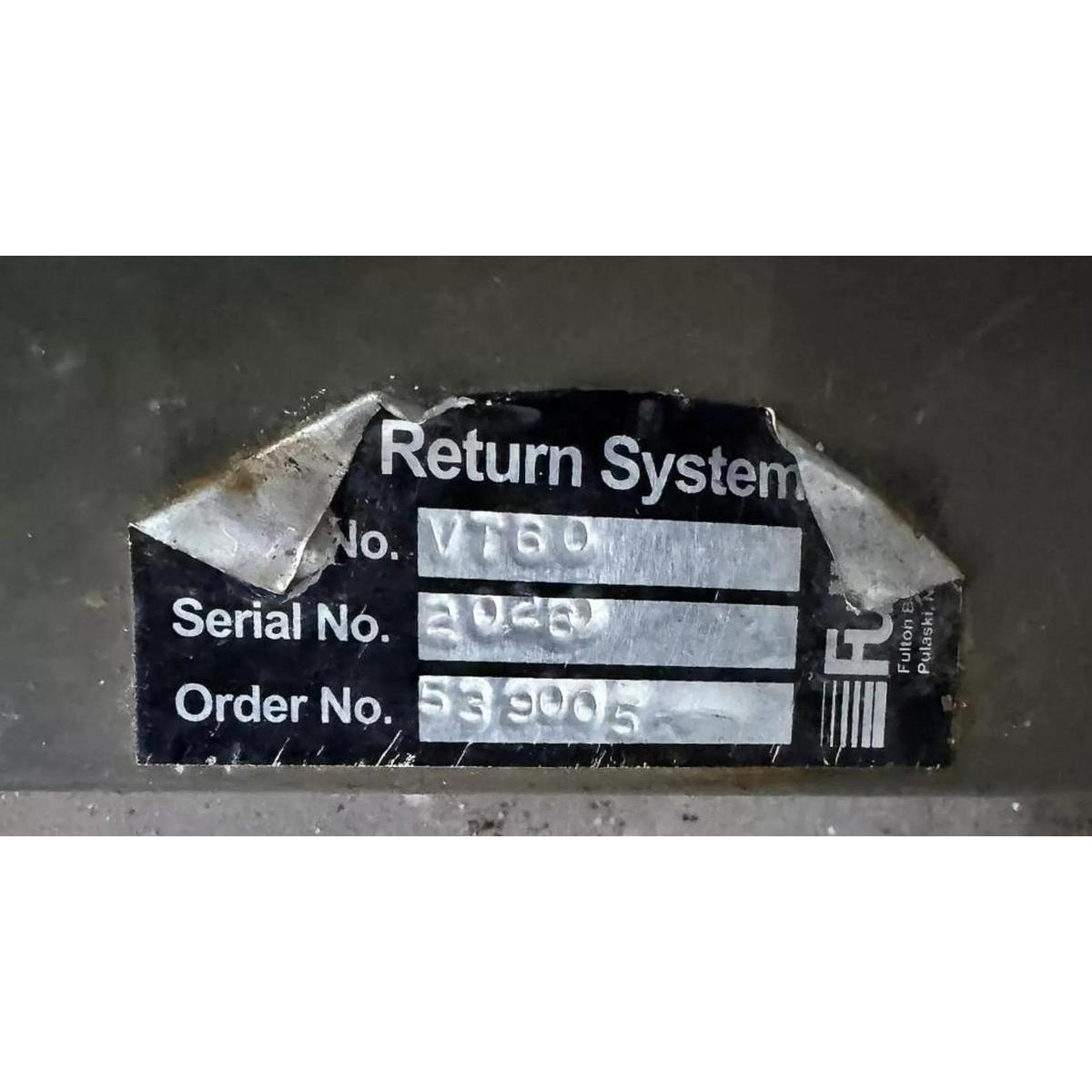 Label with 'Return System' text and serial number on a dark background