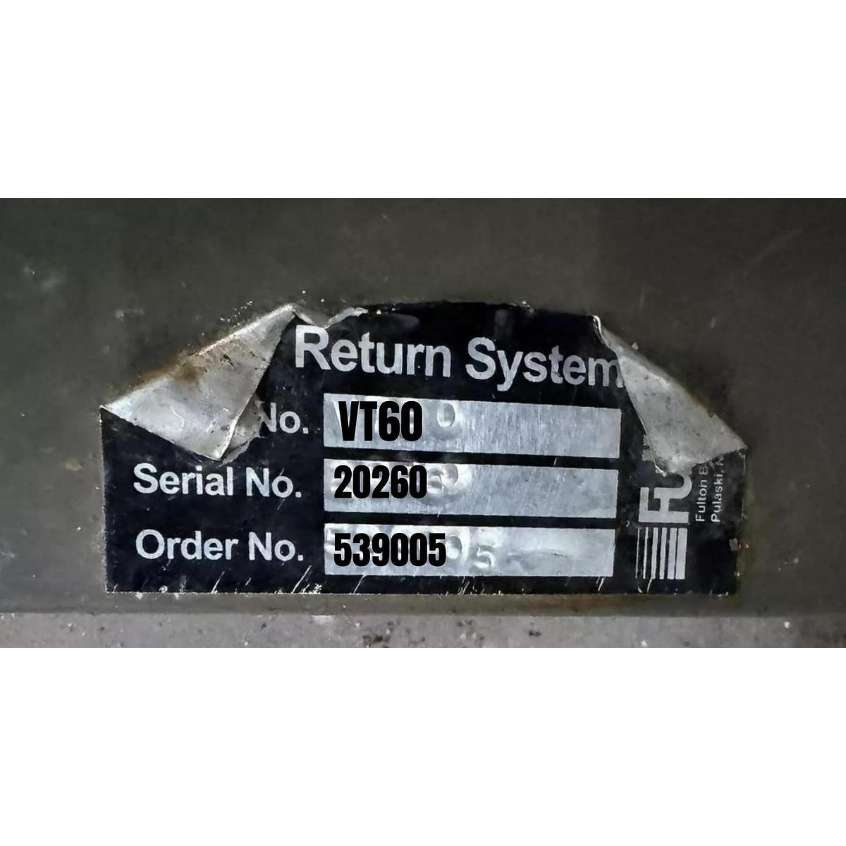 Label with 'Return System' text and serial numbers on a dark background