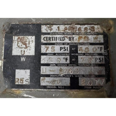 Rust-covered metal plate with certification and specifications on a white background