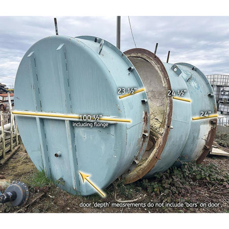 Large cylindrical metal tank with door open, showing measurements, on a cloudy day.