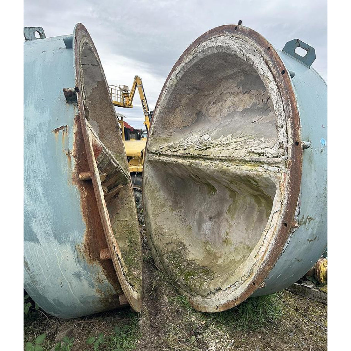 Large industrial tank with a removed section, showing rust and wear.
