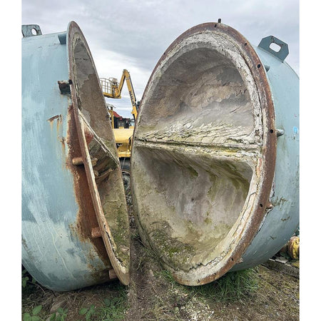 Large industrial tank with a removed section, showing rust and wear.