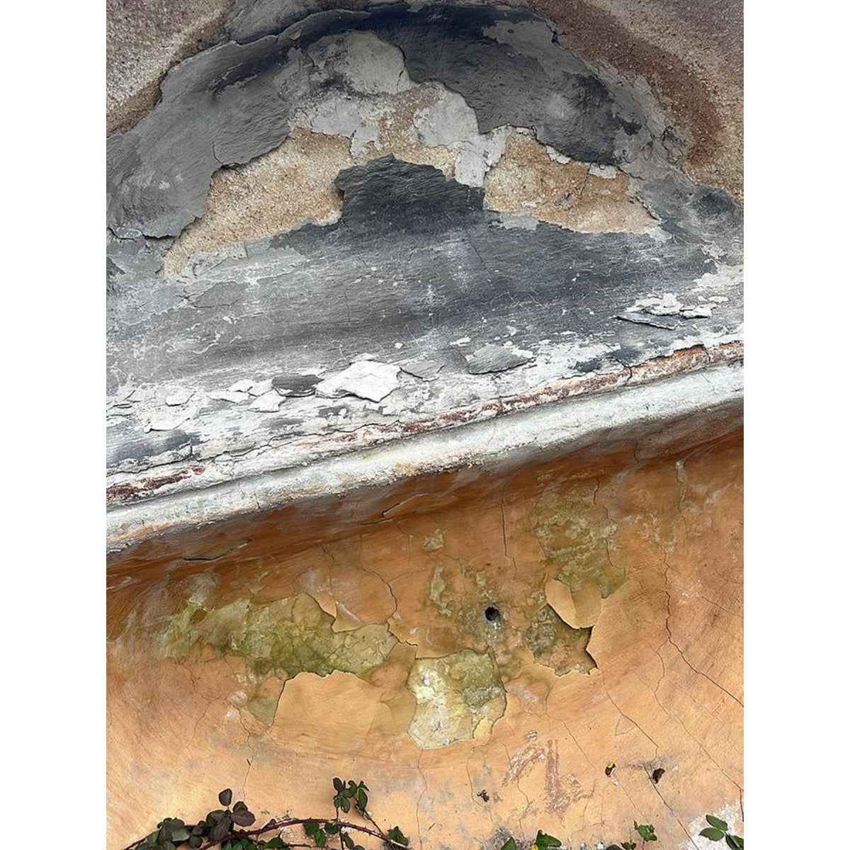 Peeling paint on a wall with a textured surface