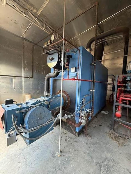 Large industrial machine in a workshop setting with visible pipes and equipment.