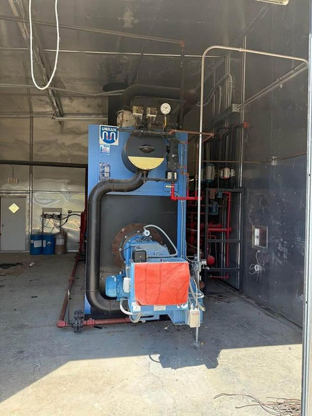 Large blue industrial machine with red cover in a warehouse setting