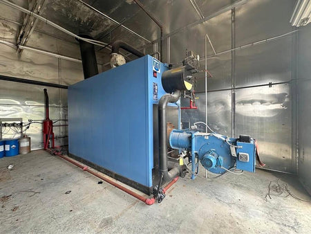 Large blue industrial machine in a room with metallic walls and floor.
