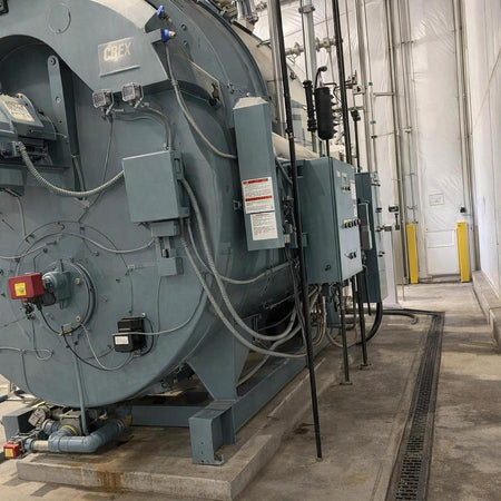 Large industrial boiler with various components in an industrial setting