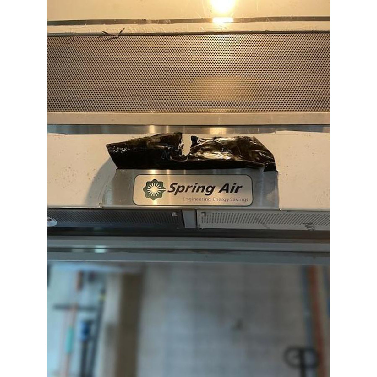 Spring Air KES-ISH commercial kitchen exhaust hood closeup showing Spring Air Engineering Energy Savings logo badge and perforated stainless steel grease filter panel